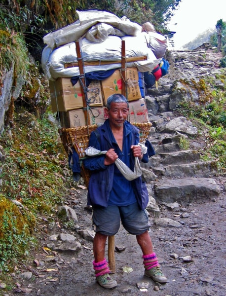 Schwer beladener Sherpa bei Rast