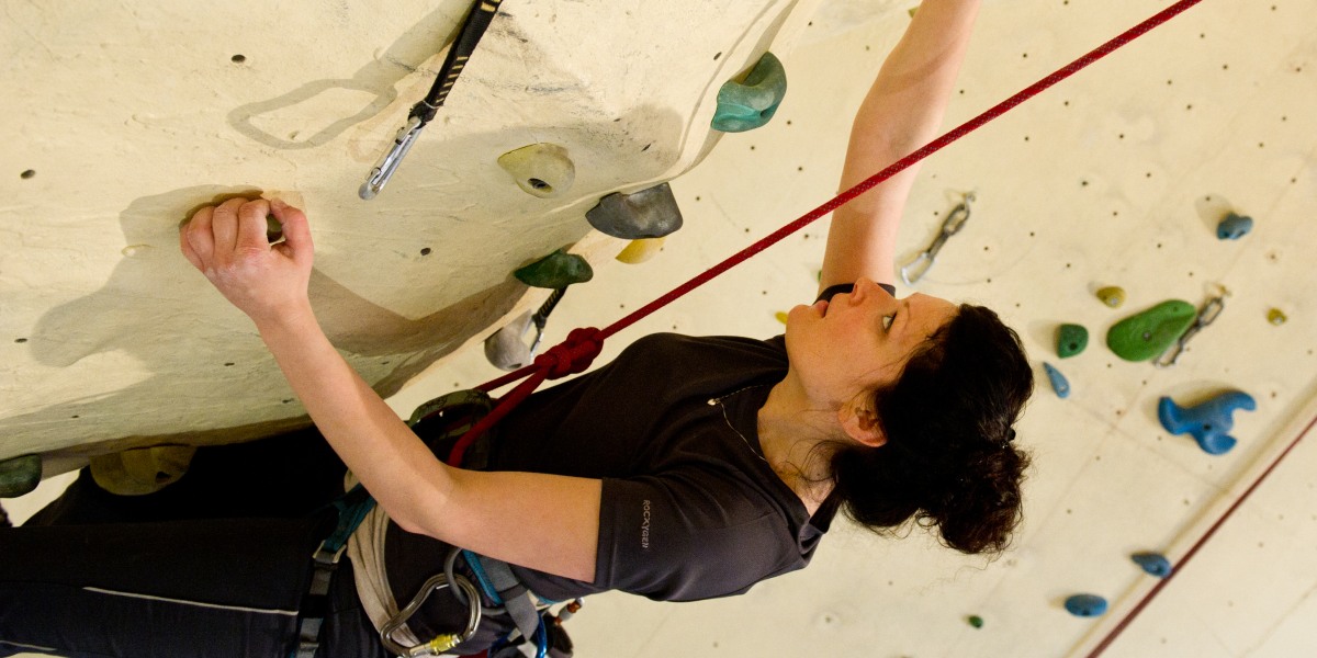                       Eine junge Frau trainiert in der XXL-Kletterhalle in Dresden an einer Kletterwand.