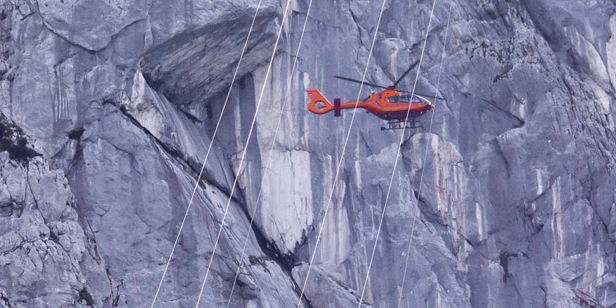 Der Rettungshubschrauber Christoph 14 vor der steilen Kletterwand am Feuerhörndl.