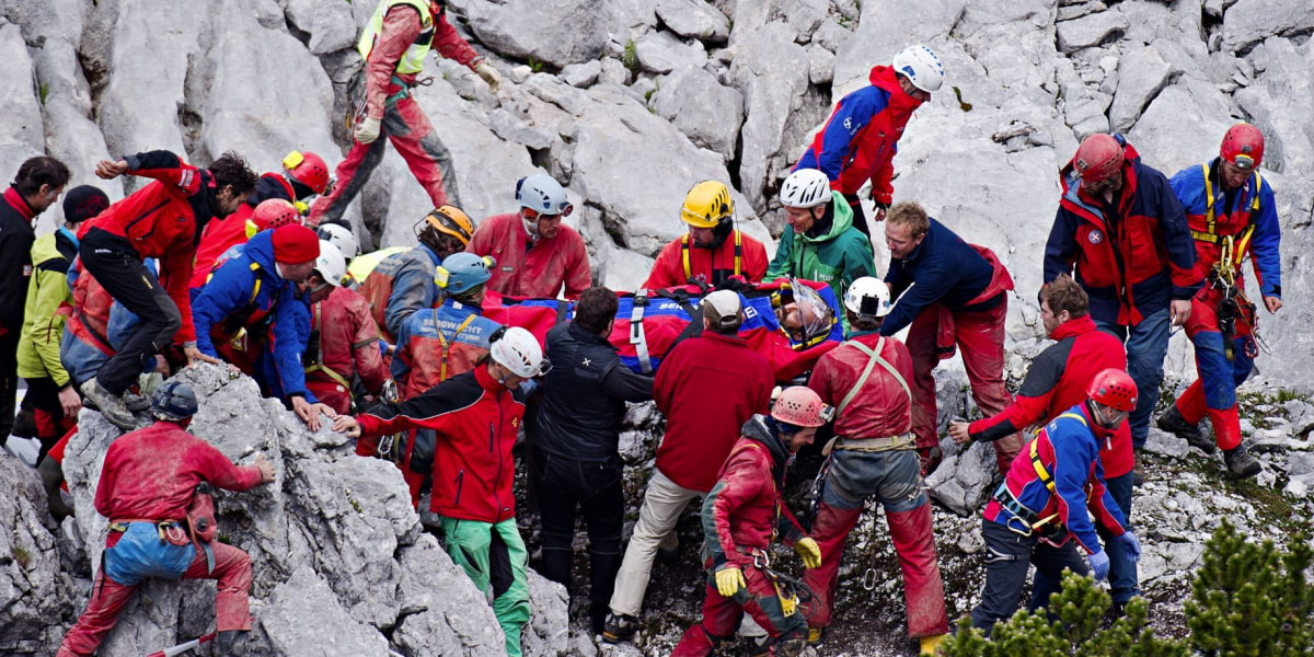 Rettungskräfte tragen im Juni 2014 den verletzten Höhlenforscher Johann Westhauser nahe des Einstiegs der Riesending-Schachthöhle auf einer Trage. Die Bergwacht Bayern sieht sich im ARD-Zweiteiler an den Pranger gestellt.