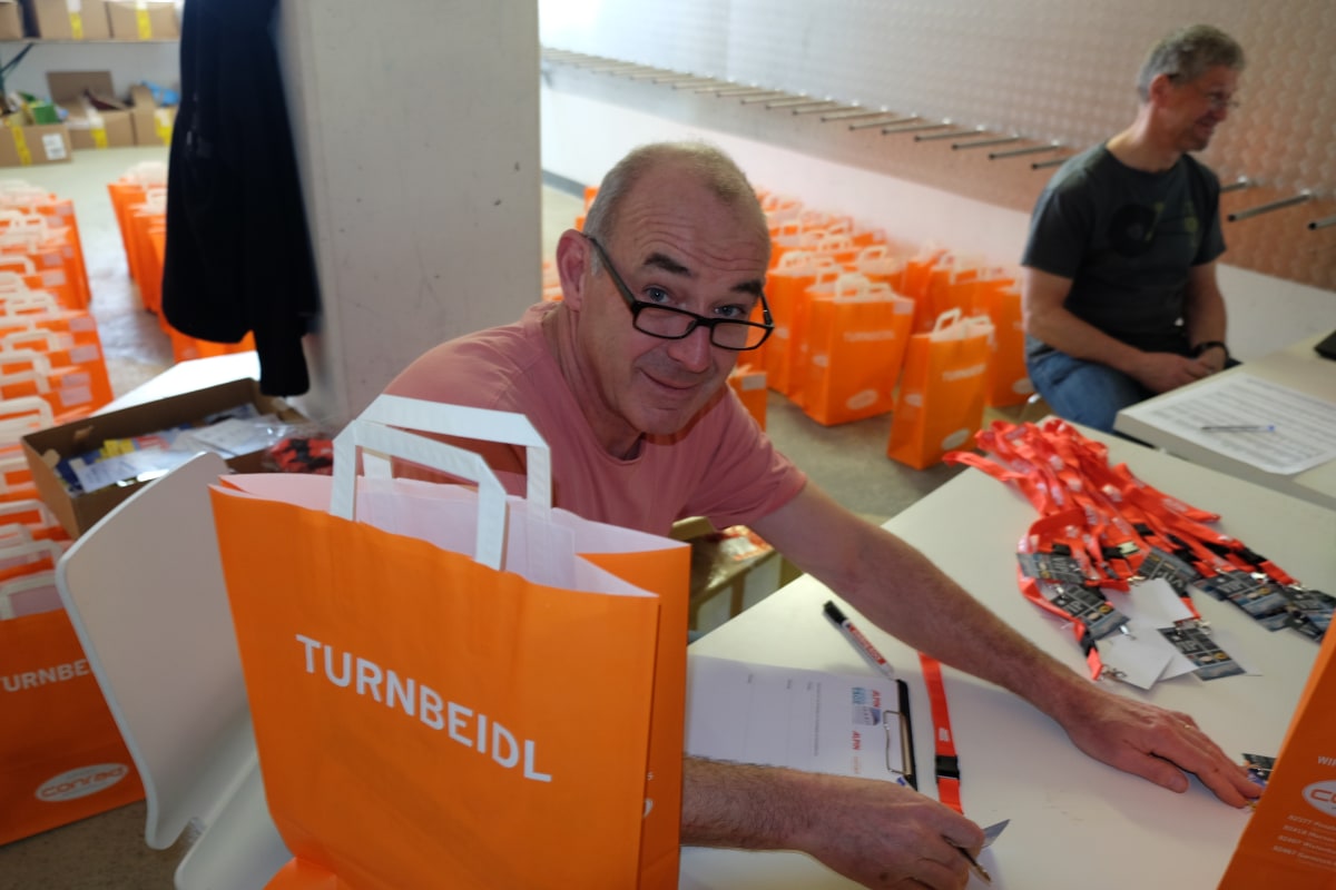 <p>Veranstalter Jürgen Saal bei der Zusammenstellung der "Turnbeidl",  der Tüten für die Teilnehmer mit Testausweis, Tourenprogramm und Liftkarten.</p>