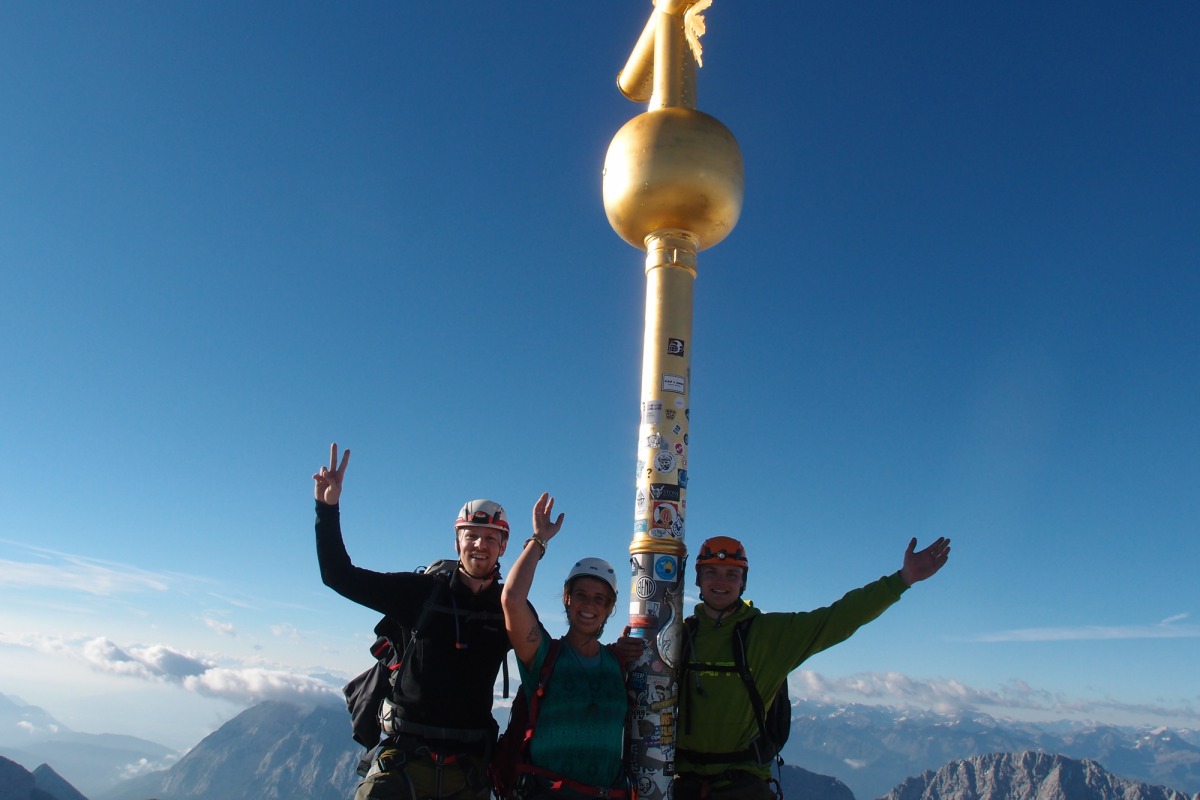 <p>Am Gipfelkreuz strahlen Matthias, Hanna und Marcel (v. l.) mit der Sonne um die Wette.</p>