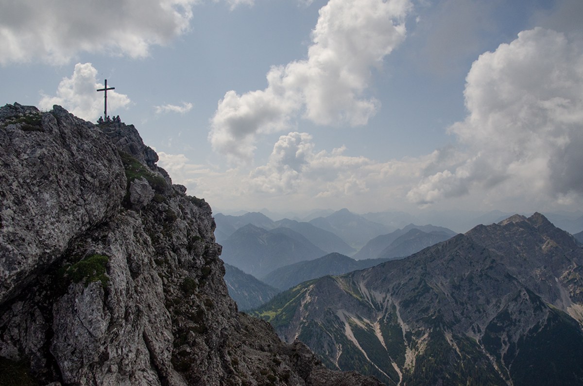 <p>Hinter  dem Gipfelkreuz der Kreuzspitze sieht man wunderbar auf den langen Grat der  Geierköpfe.  </p>