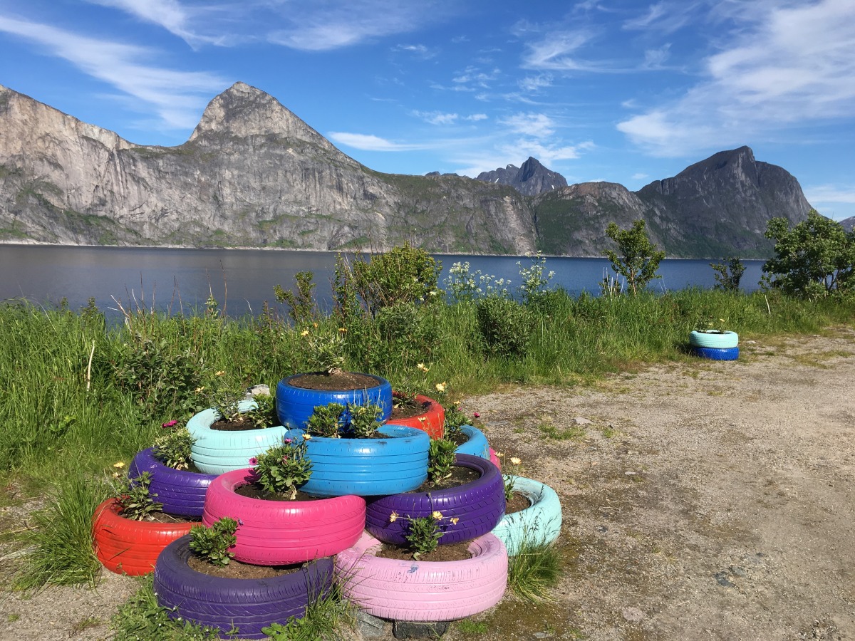 <p>Rückblick vom Parkplatz am Mefjord auf den zackigen  Felsrücken mit Segla (über dem rosa Reifen) und Barden (über der blauen  Reifensäule).</p>