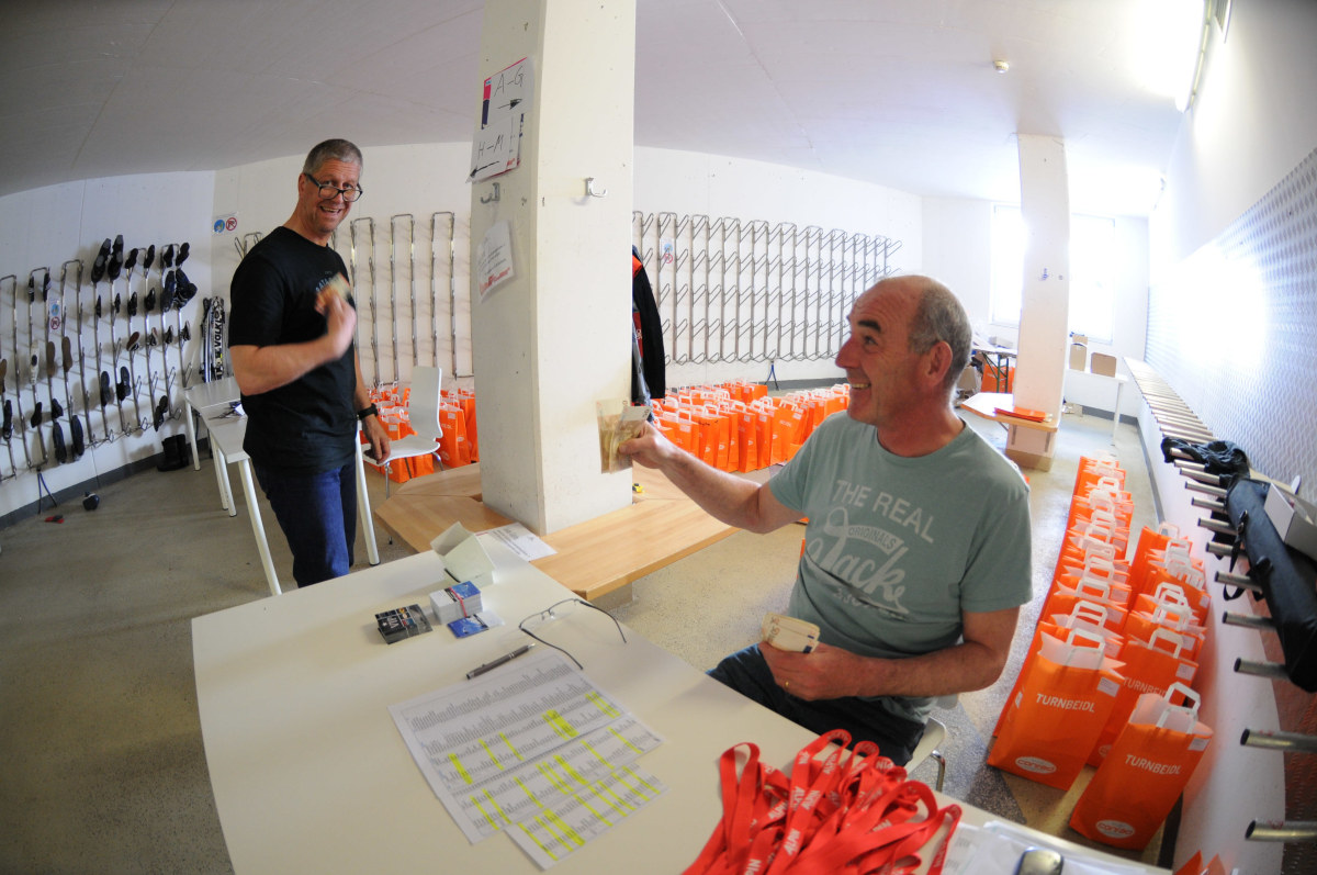 <p>Veranstalter Jürgen Saal bei der Ausgabe der "Turnbeidl", der Tüten für die Teilnehmer mit Testausweis, Tourenprogramm und Liftkarten.</p>