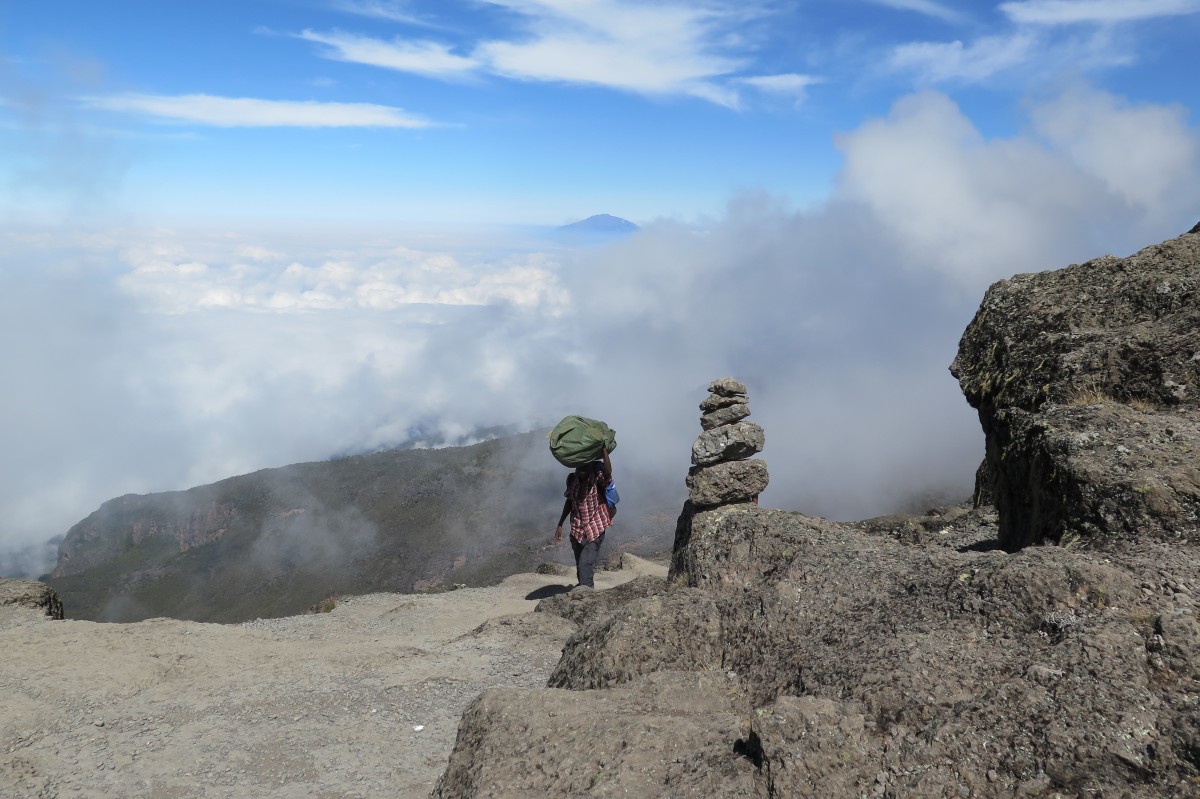 Träger am Kilimanjaro, im Hintergrund Mt. Meru