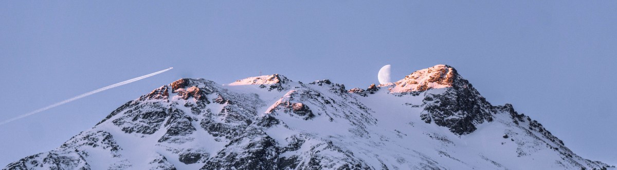 Früher Wurm hat einen Vogel- Monduntergang bei einer frühen Skitour