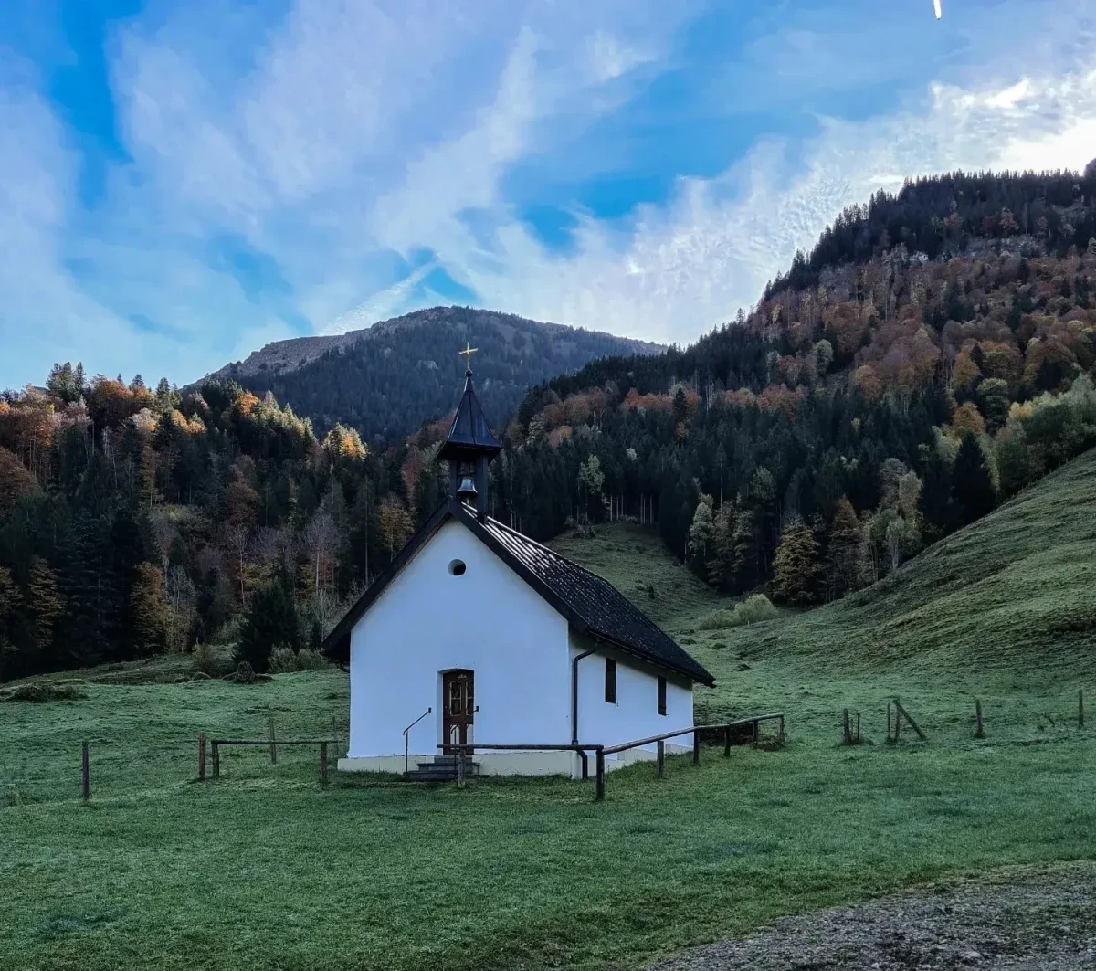 Kapelle mit herbstlichen Berghängen