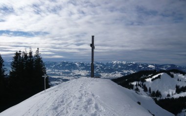 Gipfelkreuz mit Aussicht auf die Hörnerkette.