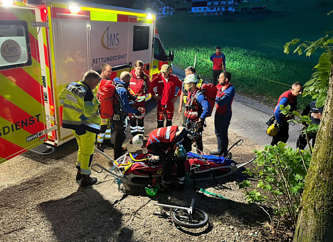 <p>Bergwacht im nächtlichen Einsatz: Einsatzkräfte und Notärzte koordinieren die Rettung am Fahrzeug.</p>