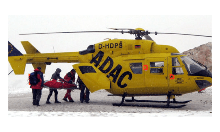 Helfer laden auf der Zugspitze einen unterkühlten Extremsportler in einen Rettungshubschrauber. Bild: dpa.
