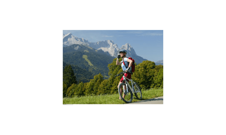Handy immer dabei: Mountainbikerin vor dem Zugspitzmassiv.