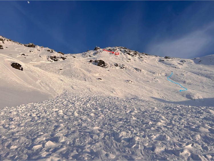 <p>Lawine mit Einfahrtsbereich (roter Pfeil), Warteposition (rotes Rechteck) und der Spur der teilverschütteten Person (in blau).</p>